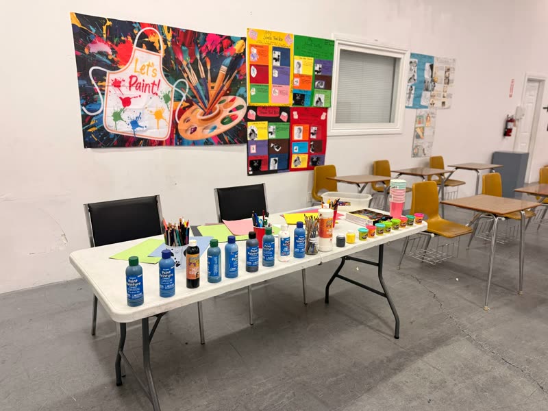 Arts and crafts table set up with paints, brushes and supplies