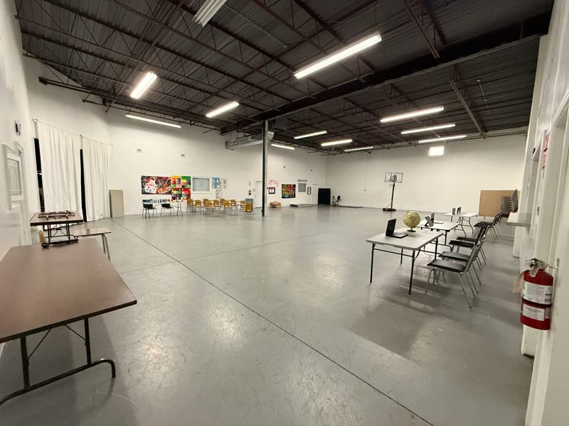 Large open activity hall with tables, chairs and wide accessible floor space